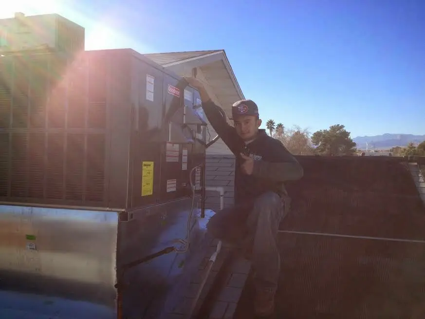 HVAC technician performing Boiler Repair on a rooftop unit in Jefferson Hills