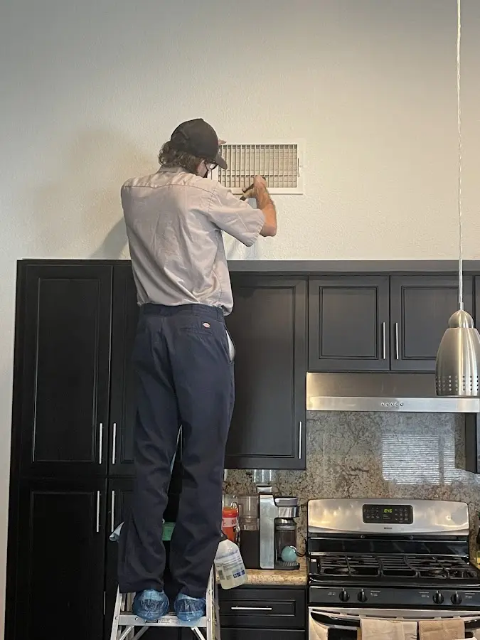 Technician inspecting an air vent during HVAC service in Jefferson Hills